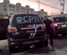 Dois policiais entrando em viatura