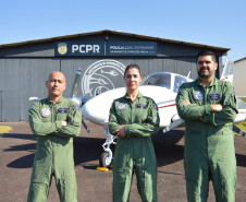 Pilotos posando para fotografia em frente a um avião