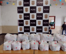 Diversas cestas sobre uma mesa. Ao fundo, banner da PCPR