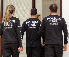 Três policiais civis de costas