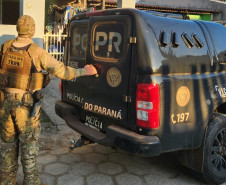 Policial civil ao lado de viatura