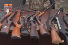 Diversas armas e munições sobre uma mesa
