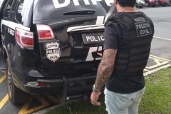 Policial civil abrindo viatura estacionada