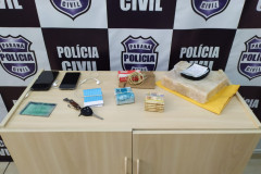 Produtos e dinheiro apreendidos, sobre um armário