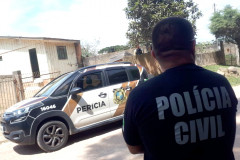 Policial civil ao lado de viatura
