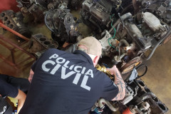 Policial civil observa motores de veículos desmontados