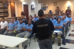 Policial de costas ministrando palestra