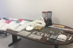 Drogas e demais produtos ilícitos apreendidos estão sobre mesa da delegacia