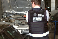 Policial civil de costas observando veículos