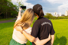 Uma mulher fazendo um selfie junto a uma policial civil