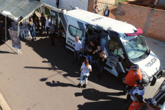 Imagem aérea mostrando policiais civis e demais pessoas junto ao veículo da PCPR