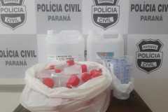 No interior de uma sacola plástica, diversos produtos apreendidos. Ao fundo, banner da polícia civil