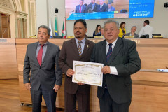 Homenageado recebendo diploma em foto posada