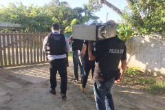 Policiais civis levando computador apreendido