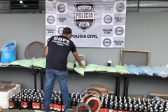 Policial civil agrupando material apreendido sobre uma mesa