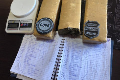 Tabletes de droga, balança e um caderno com anotações