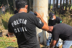 Policiais civis resgatando o corpo