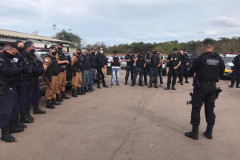 Vários policiais reunidos, recebendo instruções