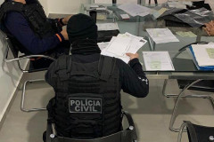 Policiais civis verificando documentos 