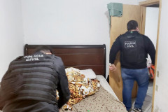 Policiais civis revistando o local