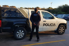Policial civil ao lado de viatura