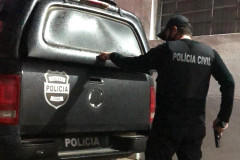 Policial civil abrindo porta-malas de viatura