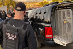 Diversos policiais civis ao lado de viatura