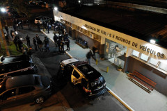 Foto aérea, com policiais reunidos em frente à delegacia