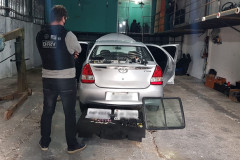 Policial civil observa veículo no interior de barracão