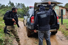 Dois policiais colocam preso no porta-malas da viatura