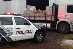 Viatura estacionada ao lado de caminhão carregado