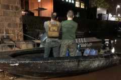 Policiais de costas, dentro do barco