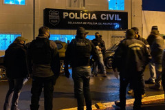 Policiais civis reunidos em frente à delegacia, recebendo instruções para a operação