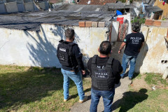 Policiais civis em frente à residência