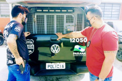 Policiais civis ao lado de viatura