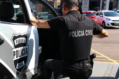 Policial civil entrando em viatura