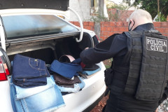 Policial civil com material apreendido, no porta-malas de um veículo