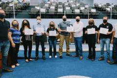 Homenageados posando para foto, segurando o certificado