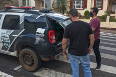 Policiais civis colocando suspeito na viatura