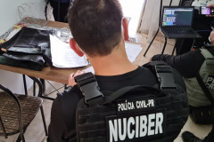 Policial civil sentado, preenchendo documentos