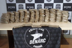 Diversos tabletes de droga empilhados sobre uma mesa. 