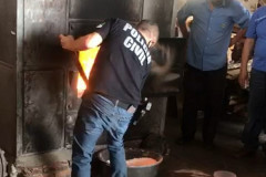 Policial civil jogando material apreendido no incinerador