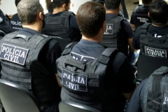 Policiais civis de costas, sentados