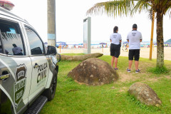 Dois policiais civis próximos a viatura, observando os veranistas