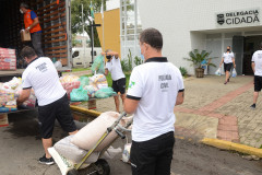 Policiais civis carregando caminhao com produtos arrecadados