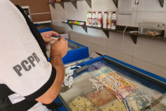 Policial realizando a apreensão na sorveteria