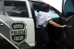 Policial civil entrando em viatura