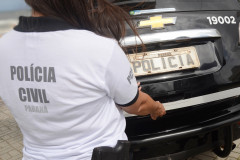 Policial civil fechando tampa de porta-malas
