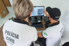 Policiais civis analisam digitais em tela de monitor