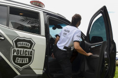 Policial civil entrando em viatura